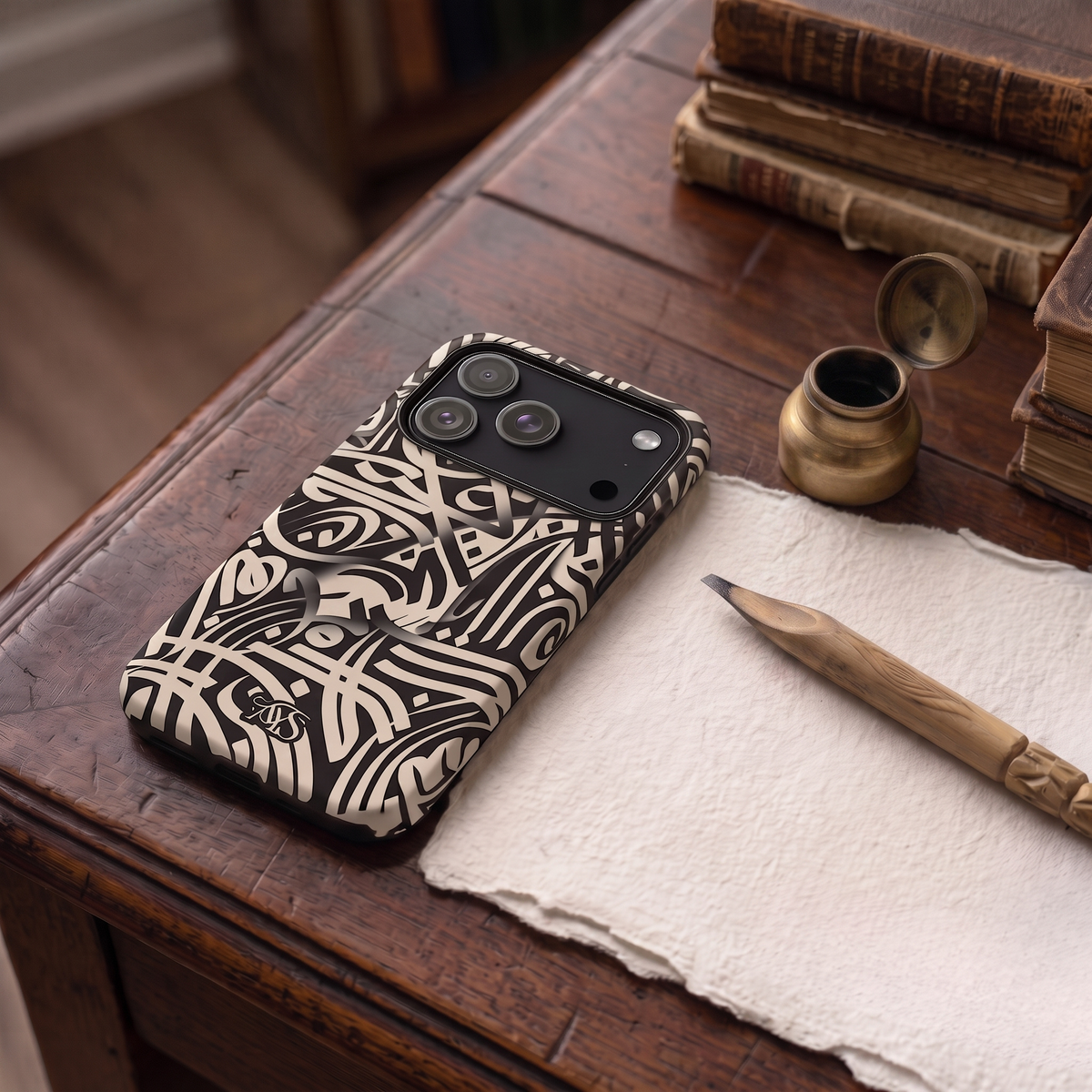 Ivory Prestige calligraphy tough phone case displayed on an antique table with a cloth, wooden pencil, ink pot and vintage books